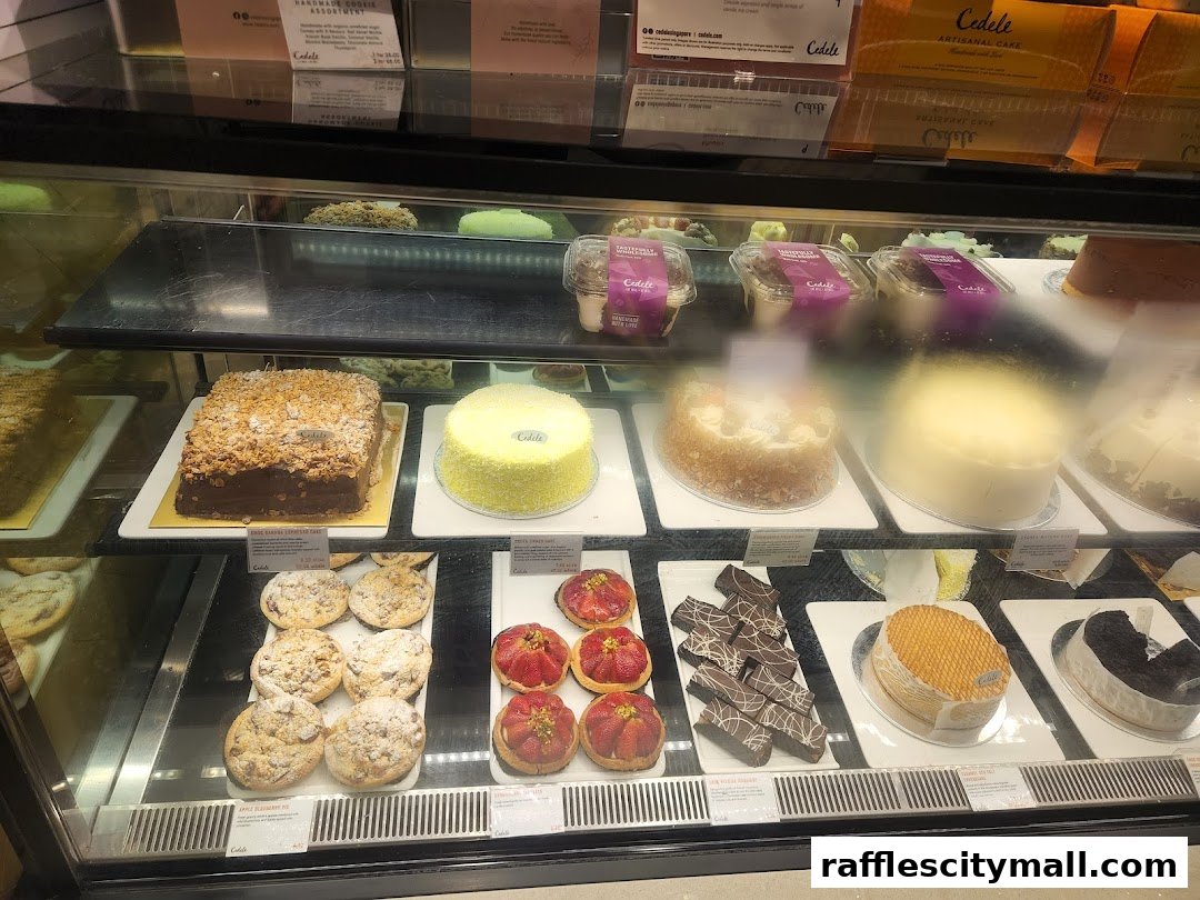 A display case filled with various cakes, pastries, and cookies from Cedele Bakery Kitchen.