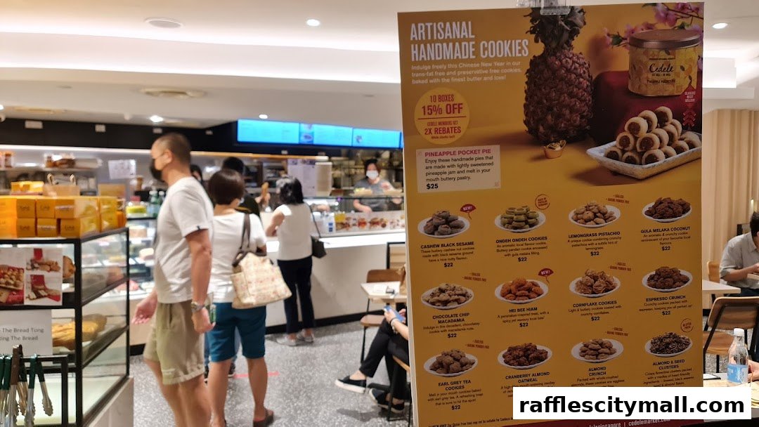 A display board showcasing artisanal handmade cookies and pineapple pocket pies from Cedele Bakery Kitchen.