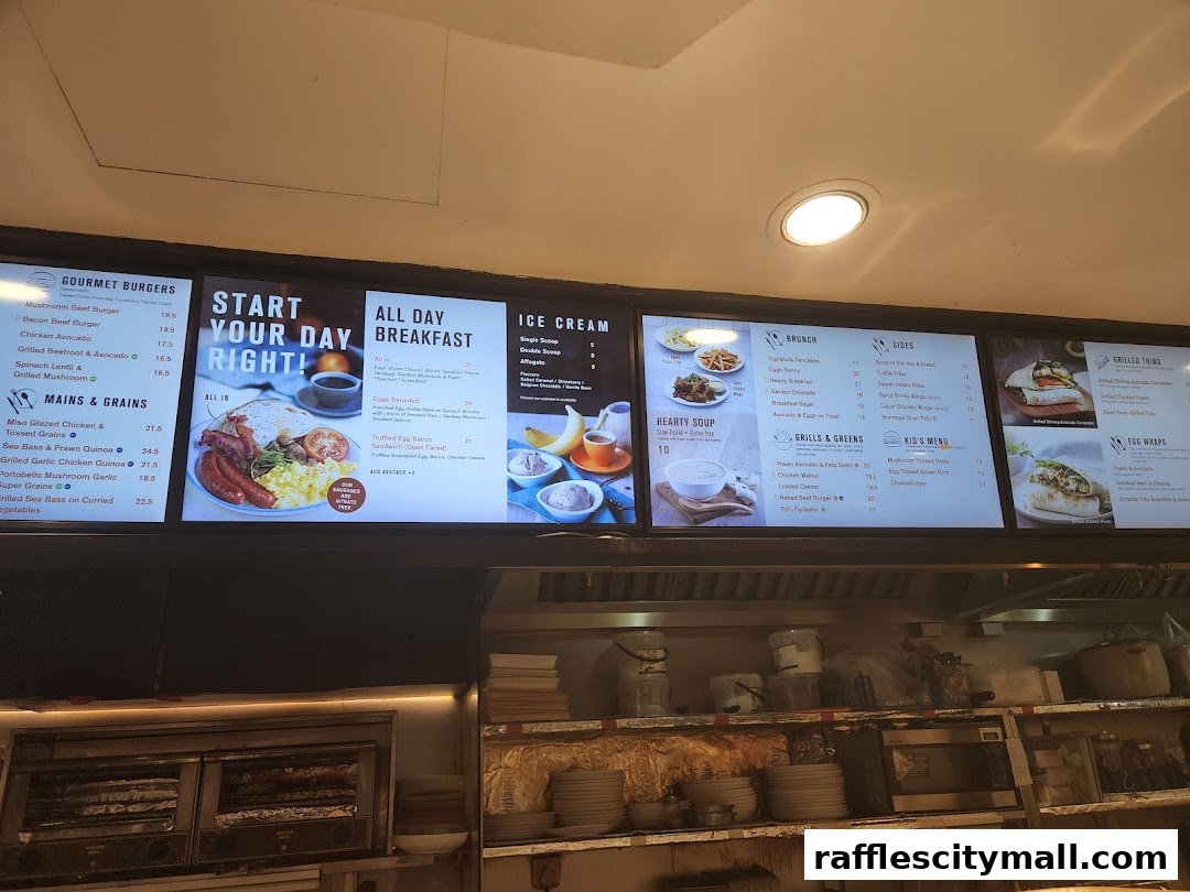 A digital menu board displaying various breakfast, brunch, and burger options with prices.