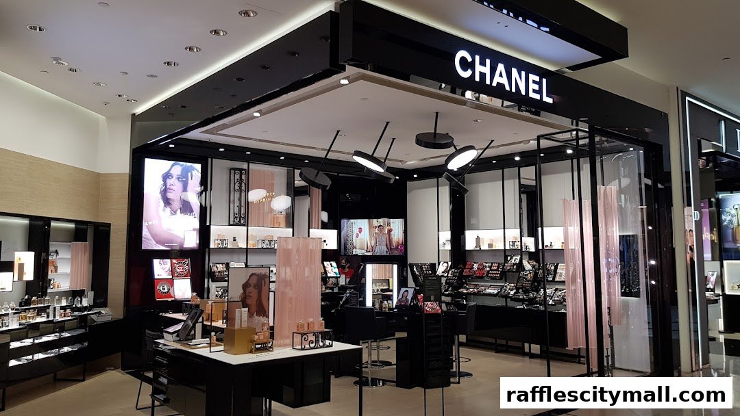 Interior view of a brightly lit Chanel beauty store with makeup displays and advertising.