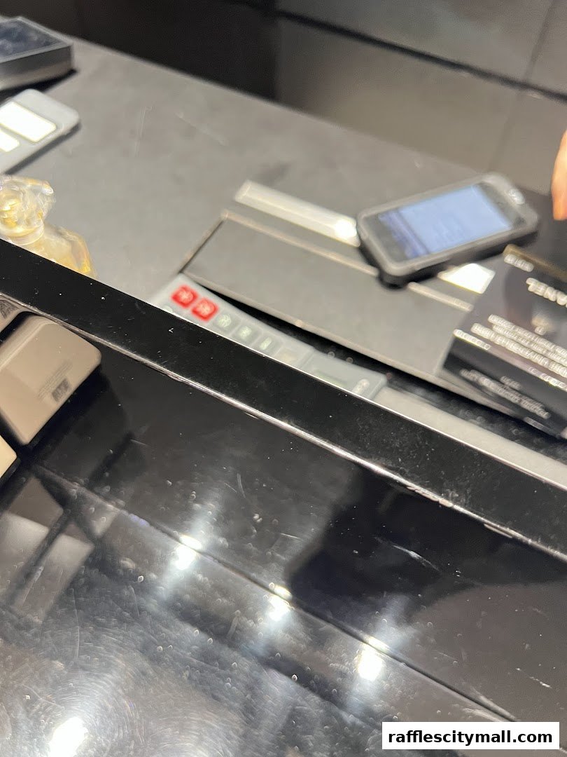 A close-up view of a Chanel counter with a phone, perfume bottle, and credit card.