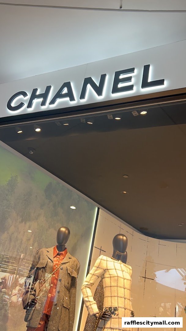 The iconic CHANEL logo above a display window featuring mannequins in stylish outfits.
