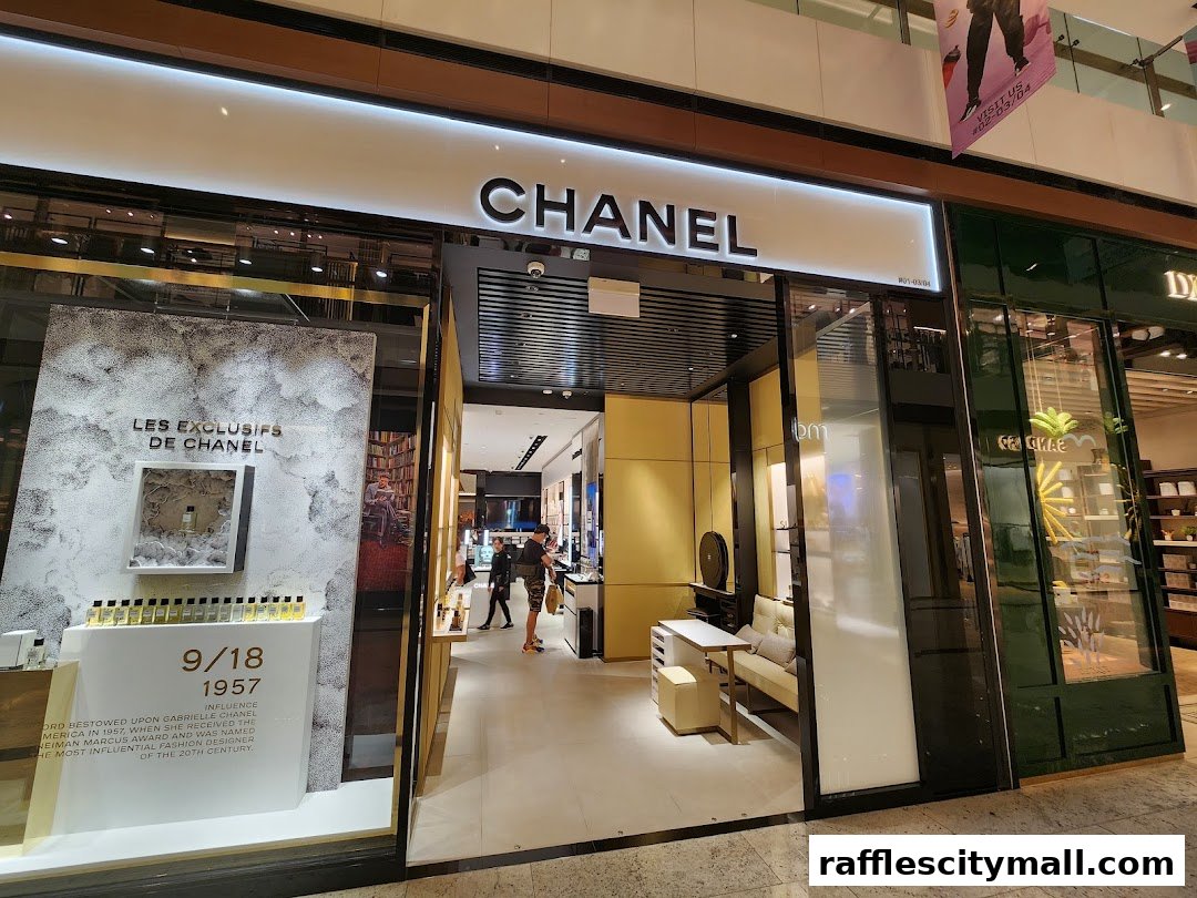 The entrance of a Chanel store, featuring a display of perfumes and promotional text.
