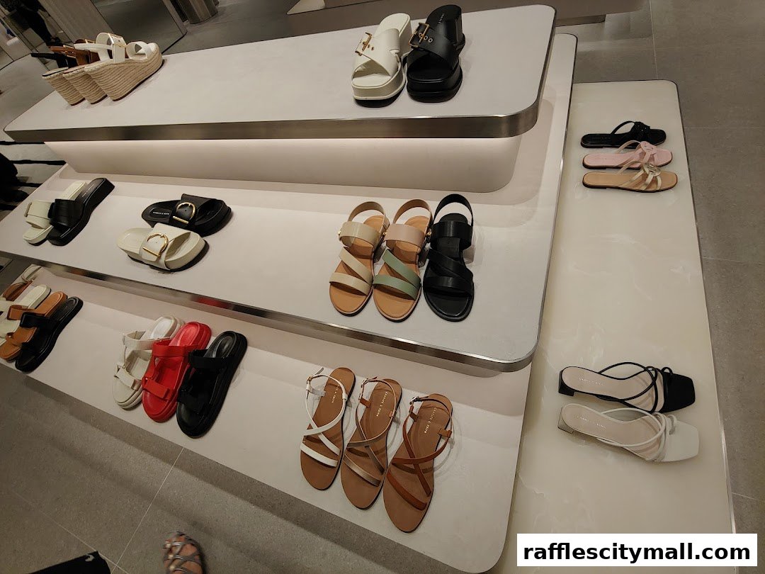 A display of various stylish sandals and shoes on white shelves in a retail store.