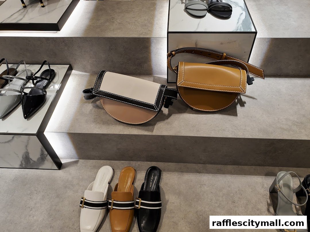 A display of stylish Charles & Keith shoes and handbags on tiered shelves.