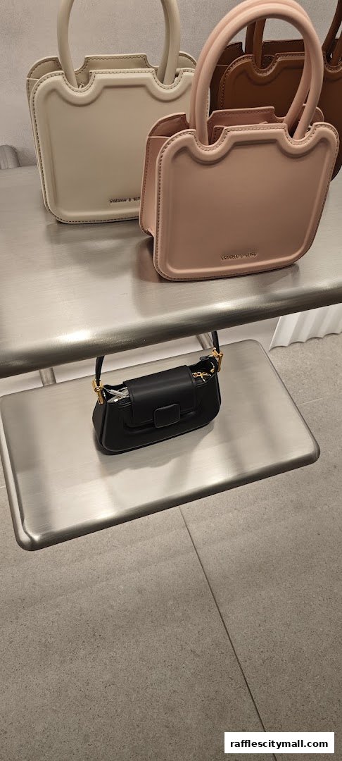 A display of stylish handbags in various colors on metal shelves.