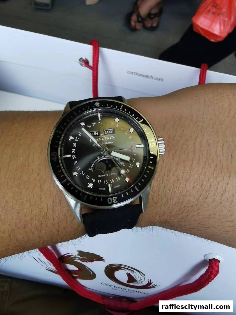 A person wearing a luxury watch with a date and moon phase complication.