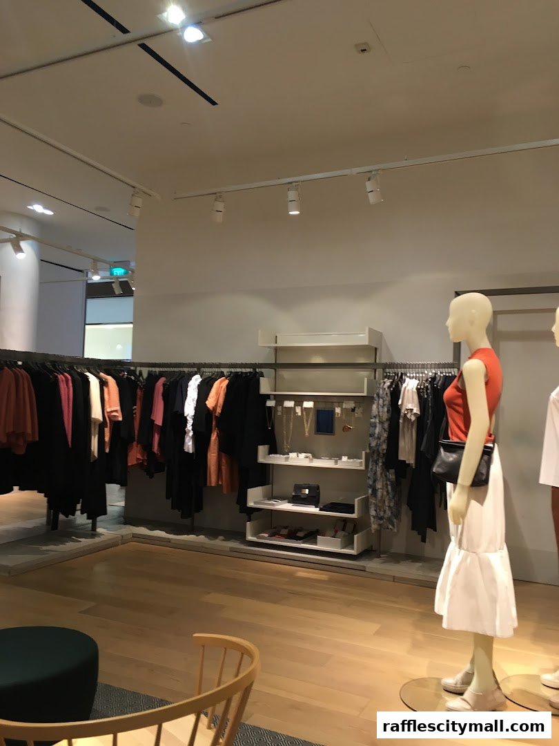 Interior view of a COS store showcasing clothing on racks and mannequins.