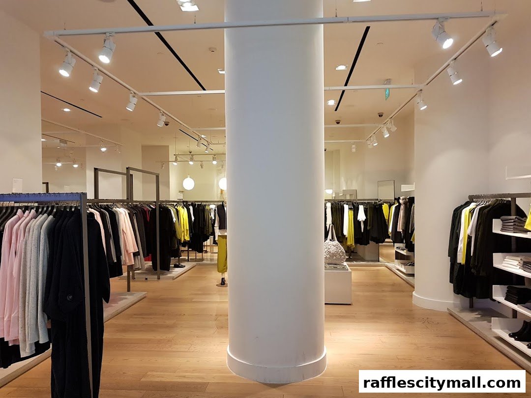 Interior view of a COS clothing store with racks of apparel and a central pillar.