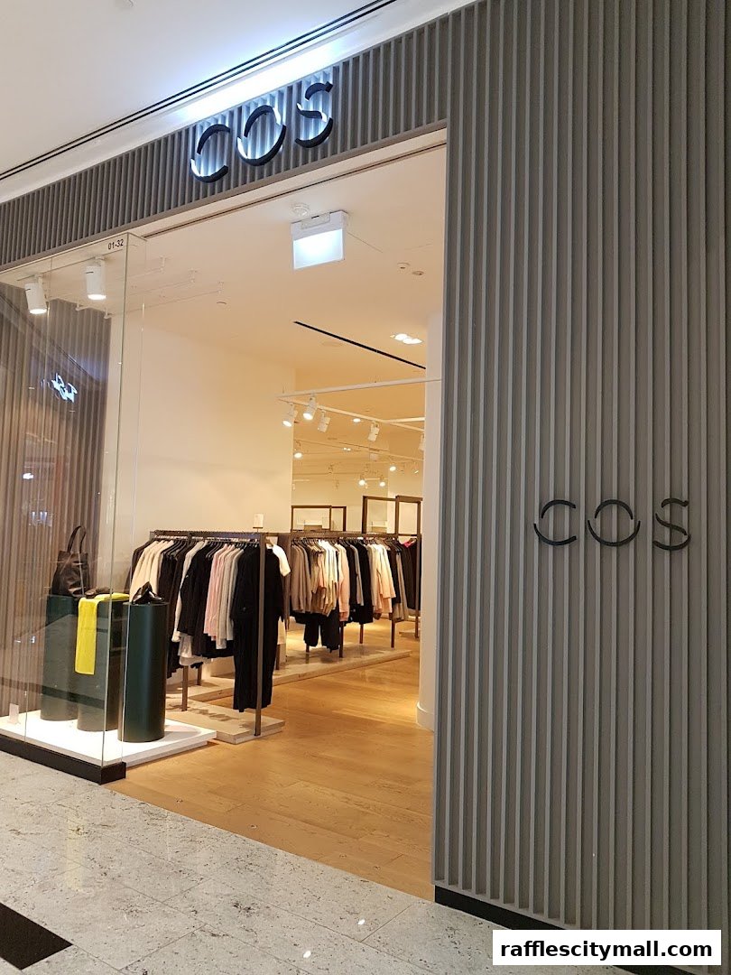 The entrance to a COS clothing store, showcasing minimalist fashion displays and a clean interior.