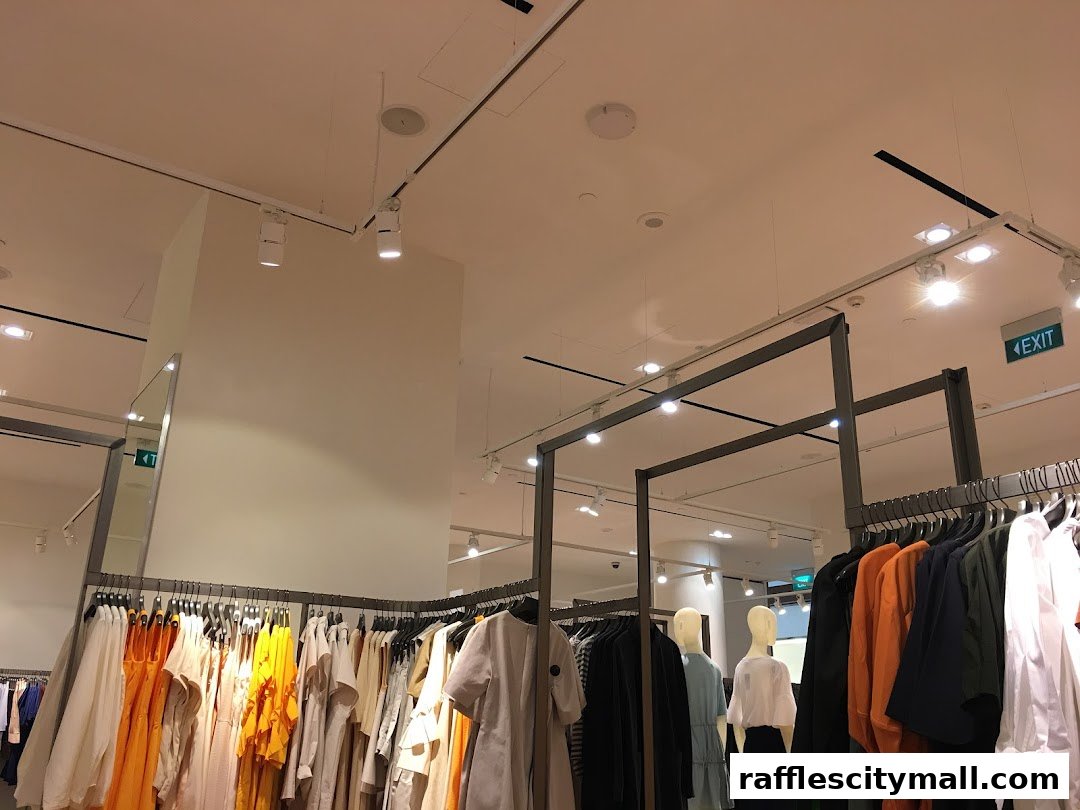 Interior view of a COS clothing store with racks of apparel and mannequins.