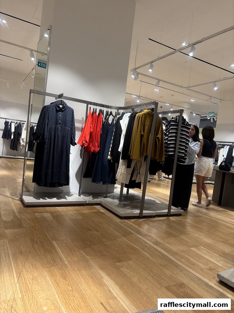 Interior view of a COS clothing store with racks of apparel and shoppers.