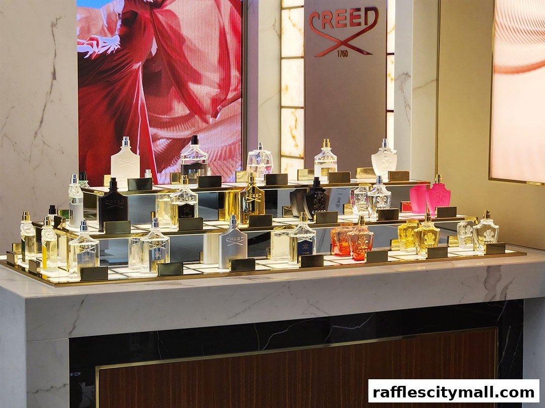 A display of Creed perfumes in elegant bottles on tiered shelves.