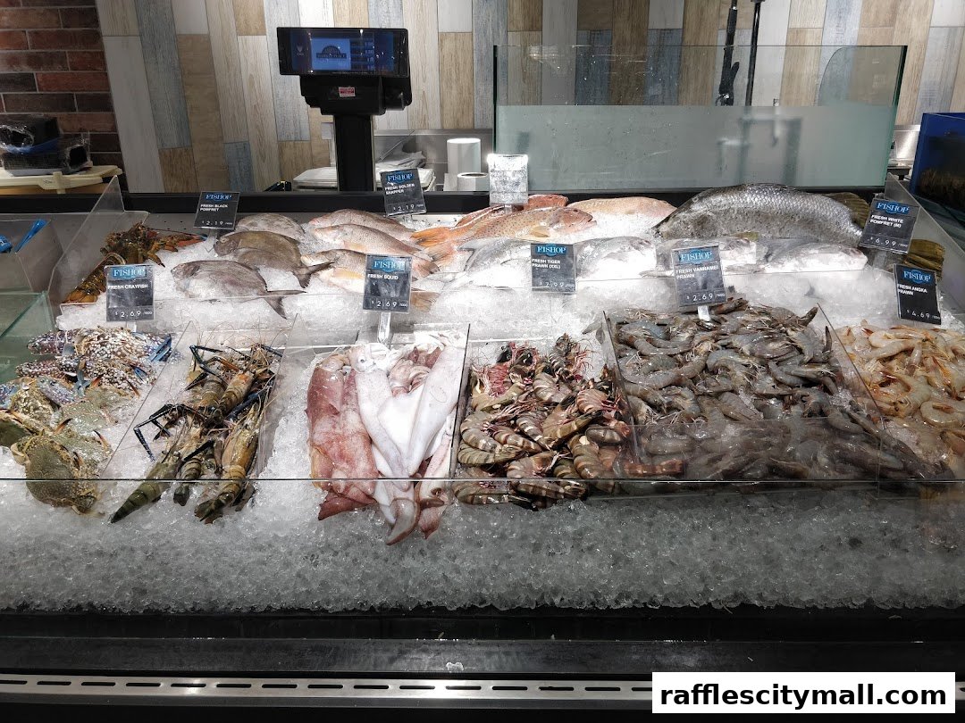 A display of fresh seafood on ice, including lobsters, prawns, squid, and fish.