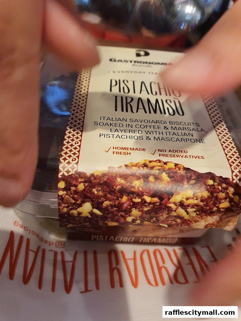 A close-up of a Pistachio Tiramisu dessert from Da Paolo Gastronomia.
