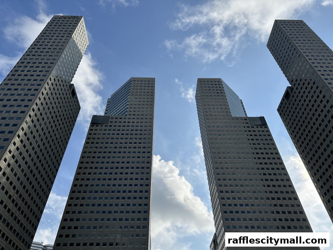 Low-angle view of modern skyscrapers against a blue sky with clouds.