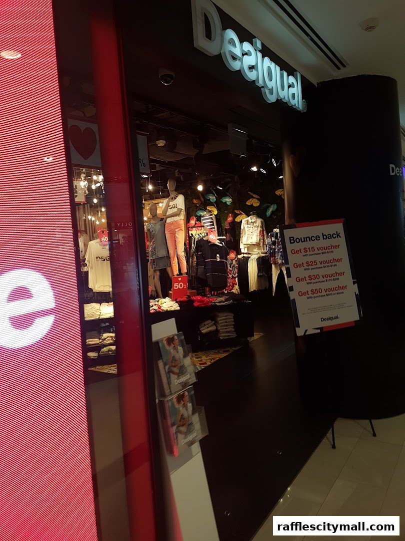 The entrance of a Desigual store showcasing mannequins and clothing displays.