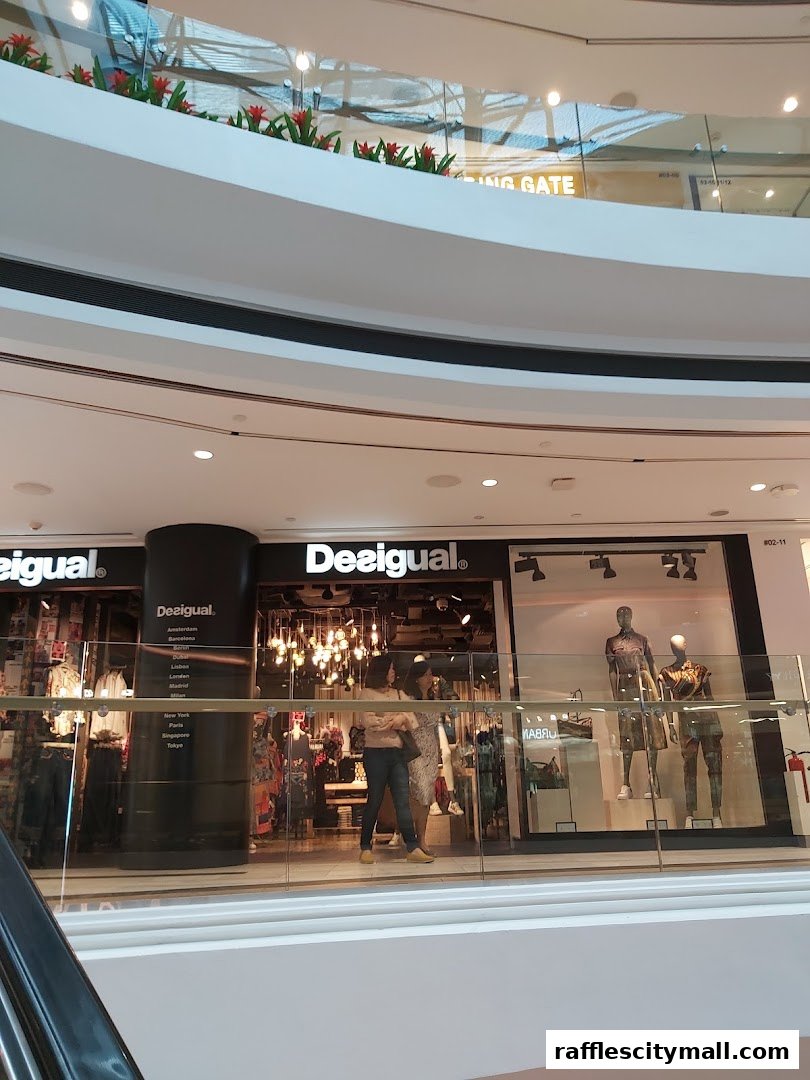 The Desigual store front displays mannequins and clothing inside a shopping mall.