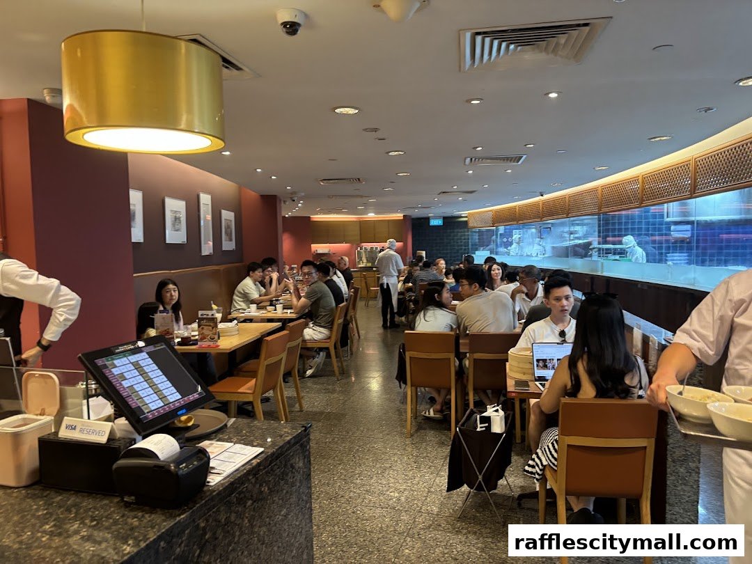 Interior view of a busy Din Tai Fung restaurant with diners seated at tables and staff serving.