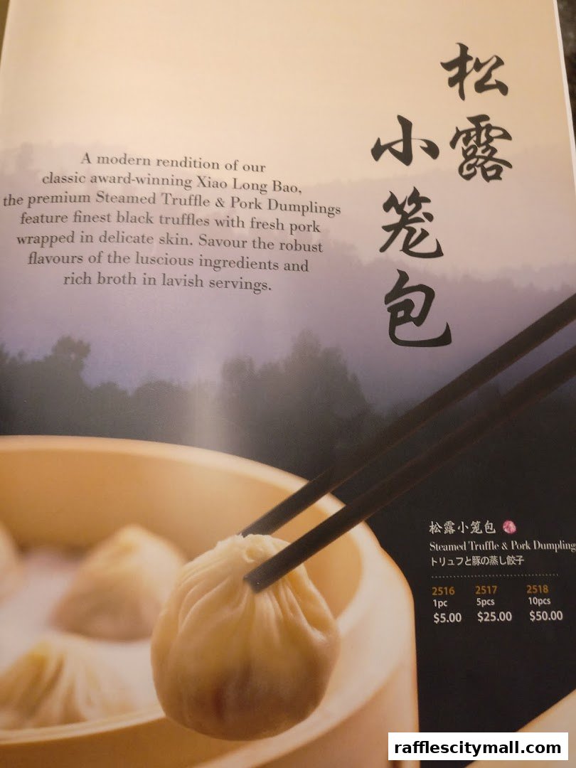 A close-up of Steamed Truffle & Pork Dumplings being held by chopsticks, with menu details.