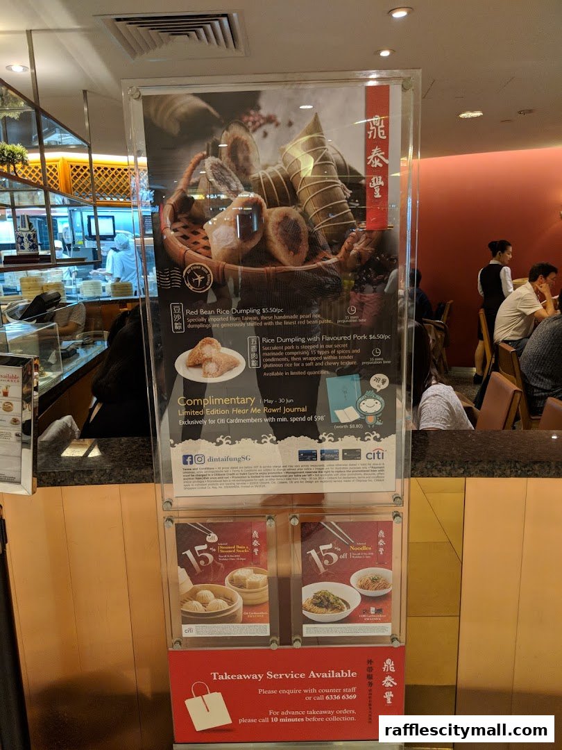 A display board at Din Tai Fung Raffles City showcasing dumplings and offering promotions.