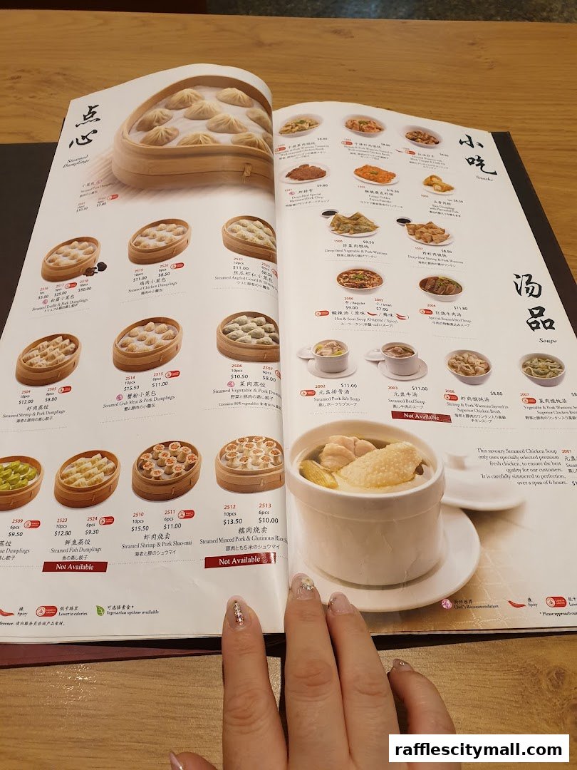 A menu from Din Tai Fung featuring various steamed dumplings and soups, with detailed descriptions and prices.