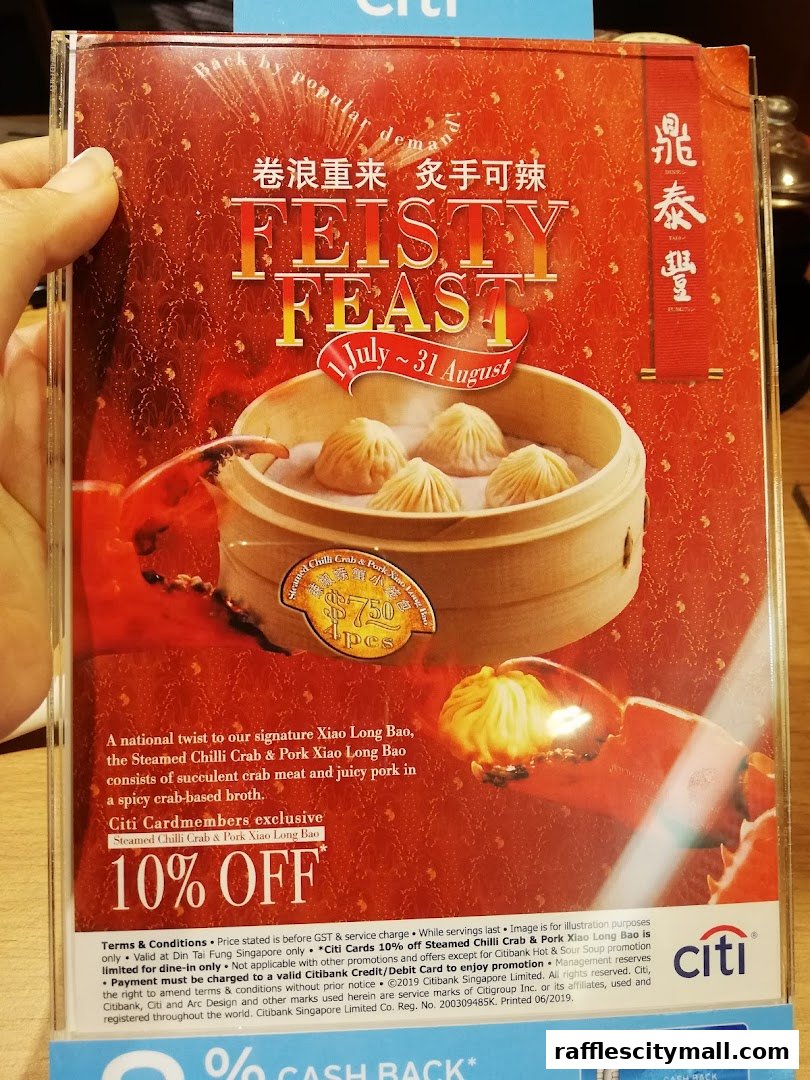 A promotional flyer for Din Tai Fung's 'Feisty Feast' featuring Steamed Chilli Crab & Pork Xiao Long Bao.
