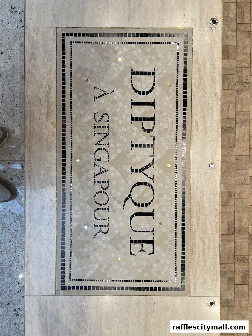 A mosaic floor sign with the Diptyque logo and 'A Singapore' text.