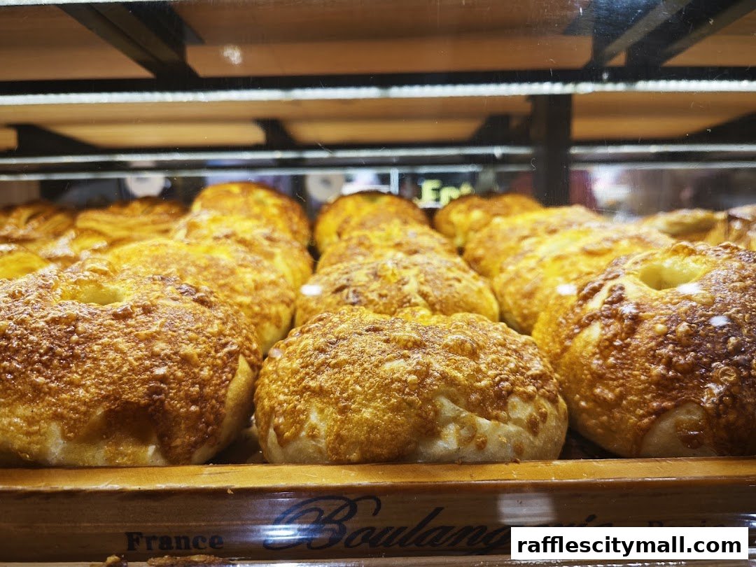 Close-up of golden-brown, cheesy baked goods displayed in a bakery case.