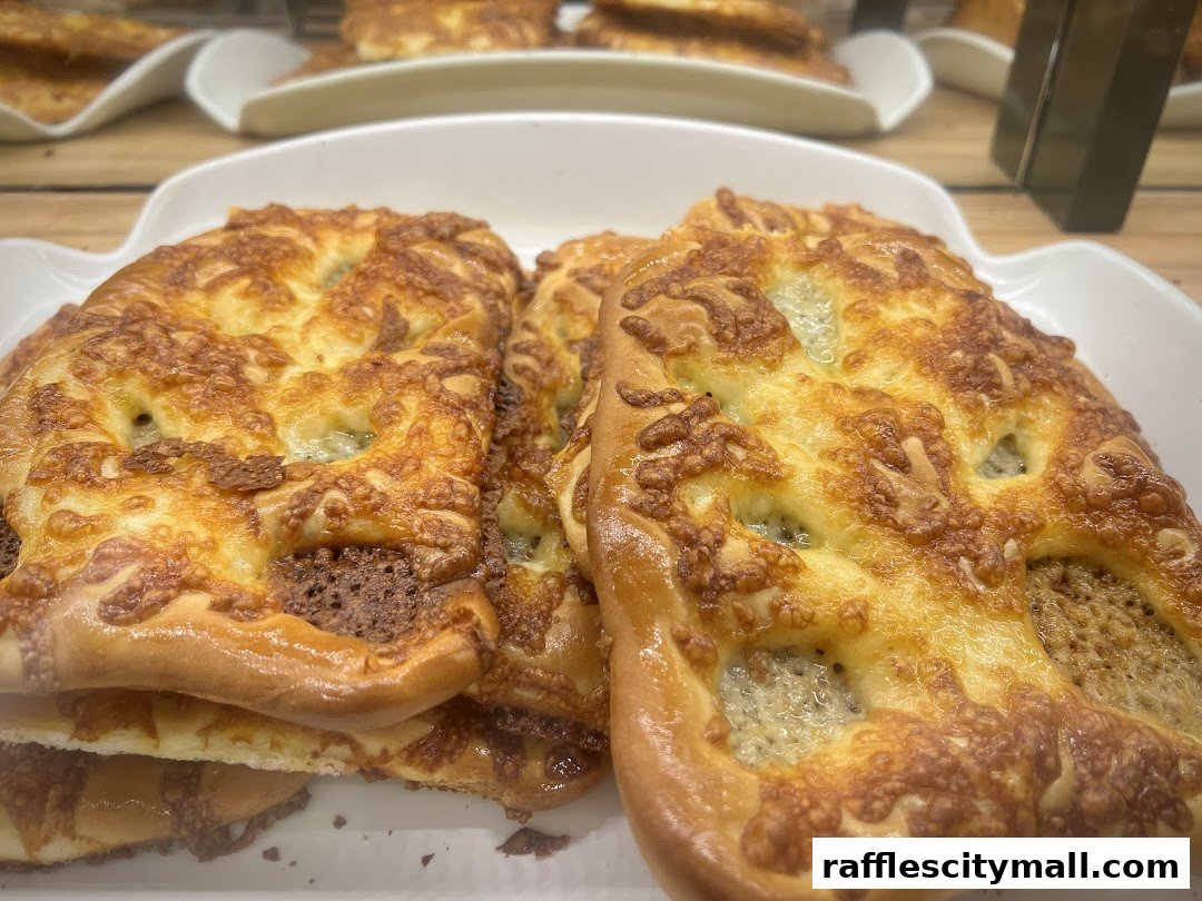 Close-up of golden-brown baked goods topped with melted cheese.