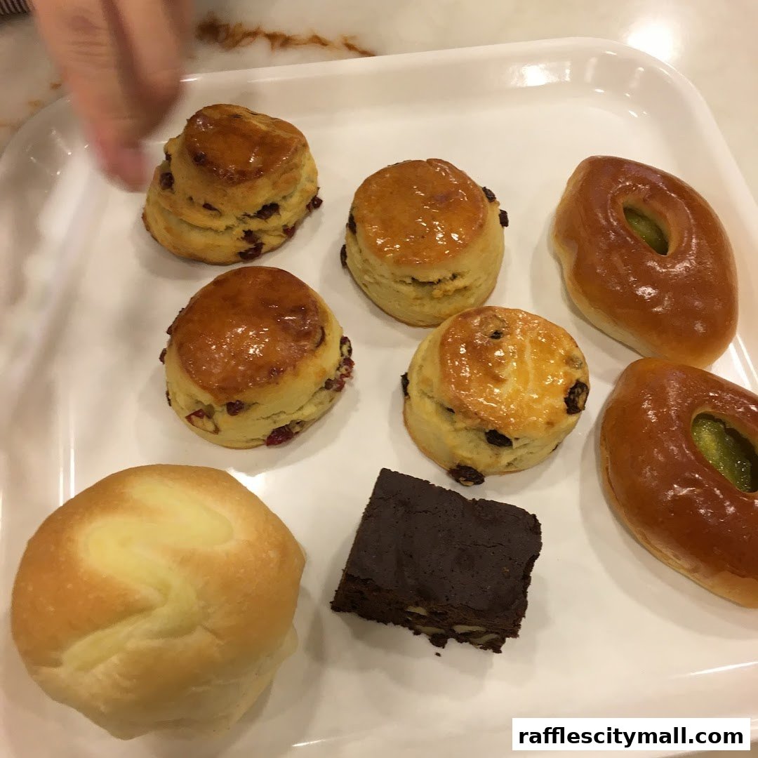 A white tray filled with assorted baked goods including scones, a brownie, and pastries.
