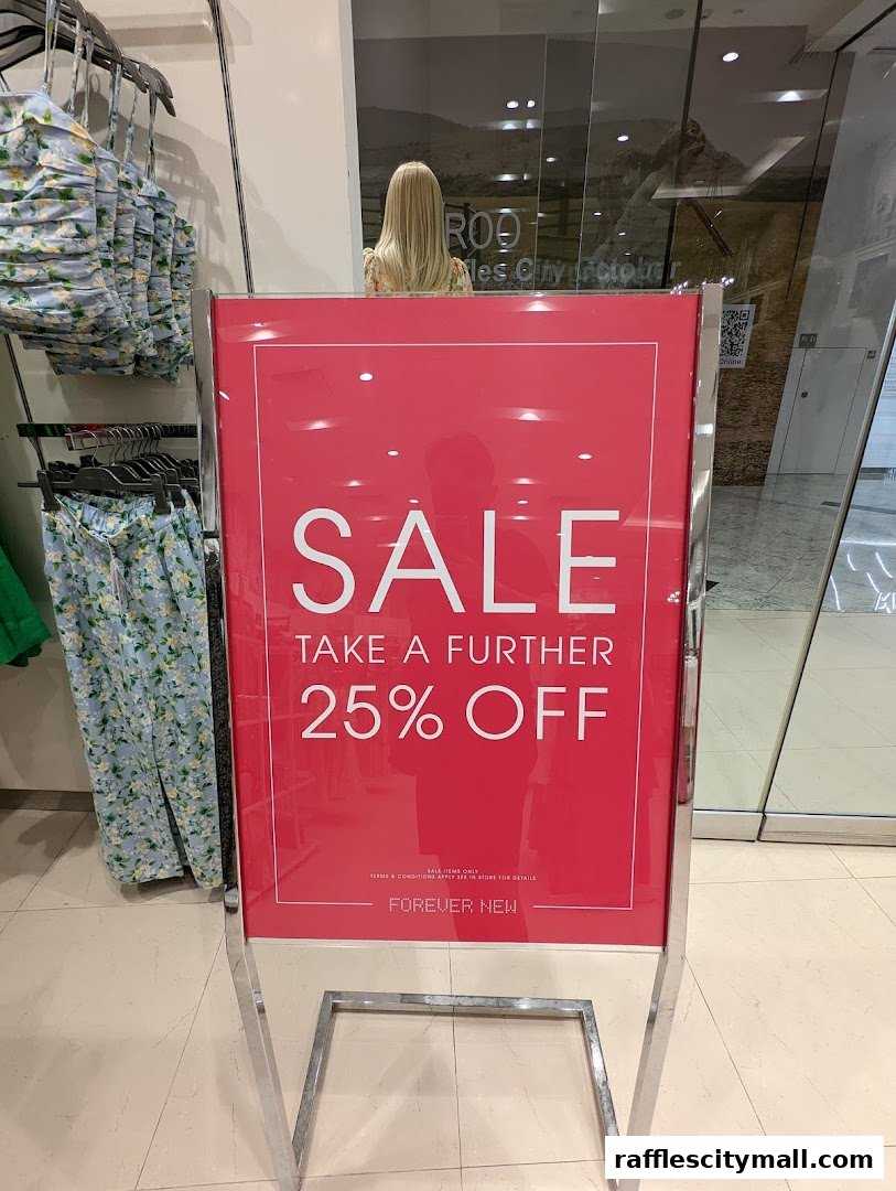 A sign advertising a 25% off sale at Forever New, with clothing visible.