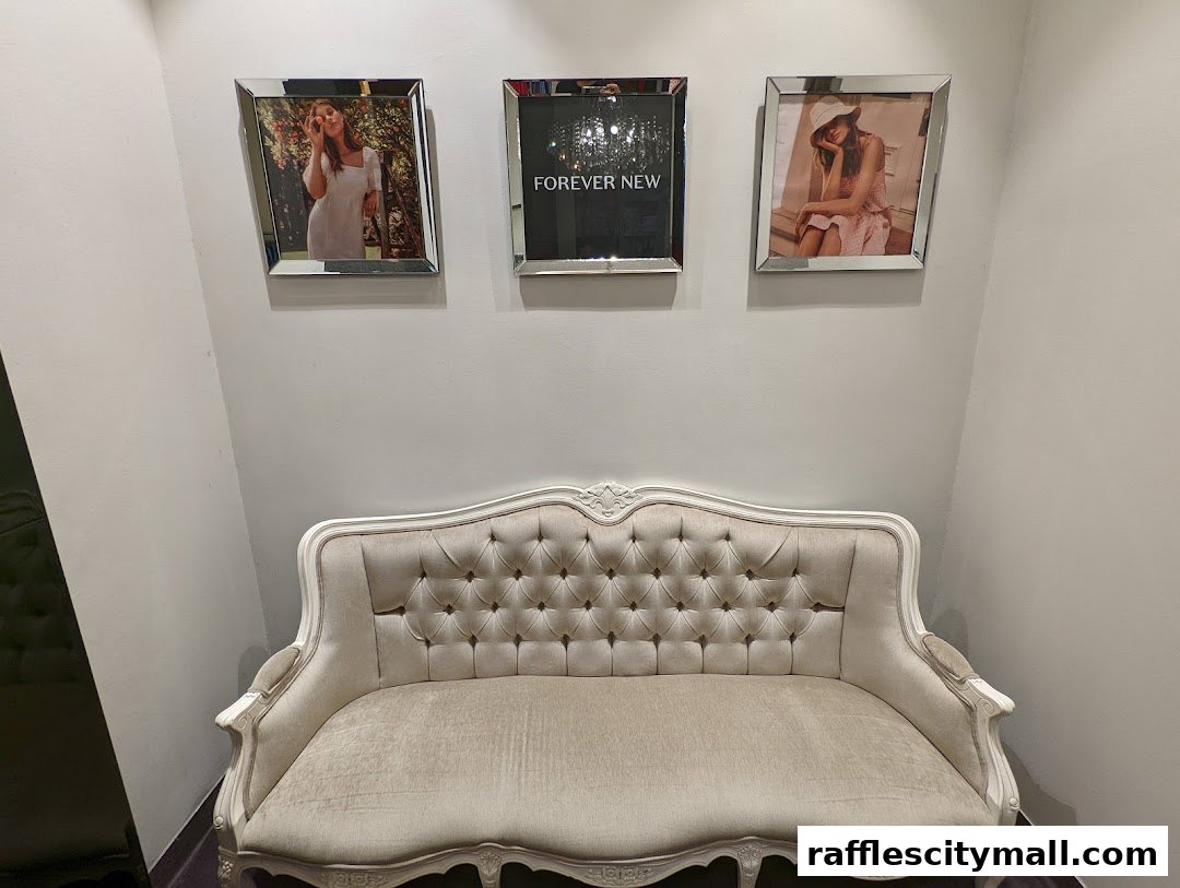 A plush sofa sits below three framed pictures, one displaying the shop's name.