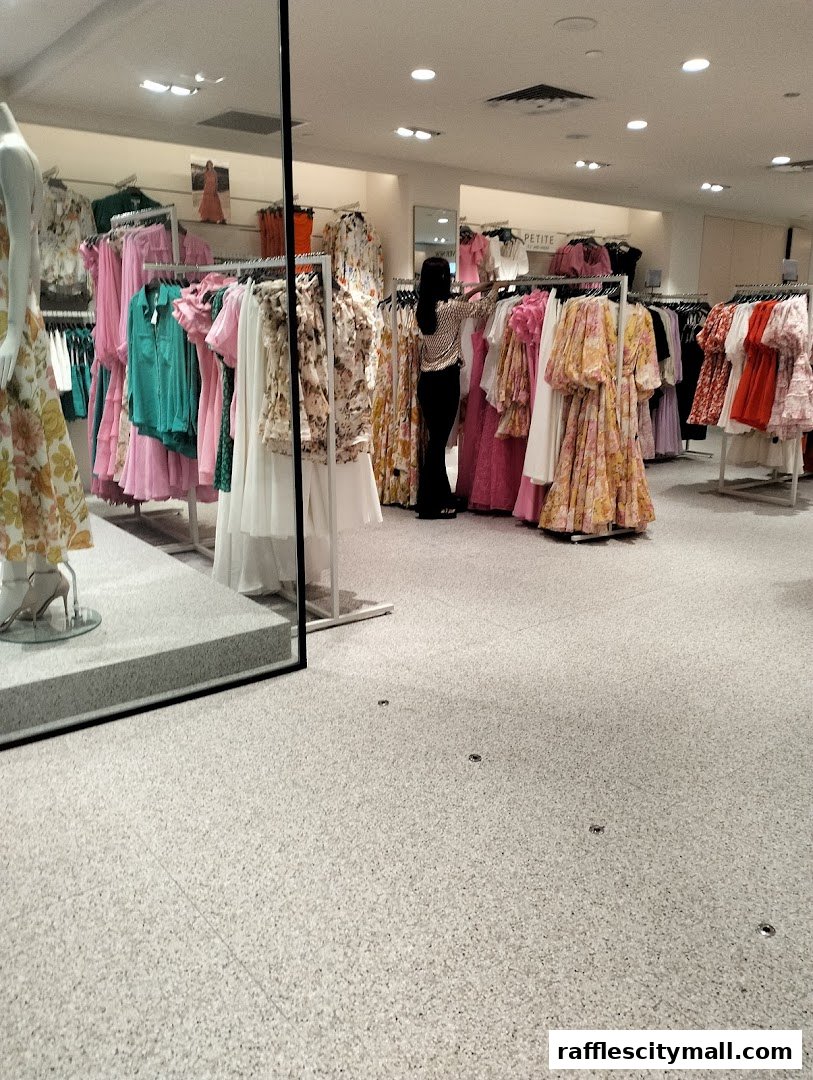 Interior view of a clothing store with racks of colorful dresses and a shopper browsing.