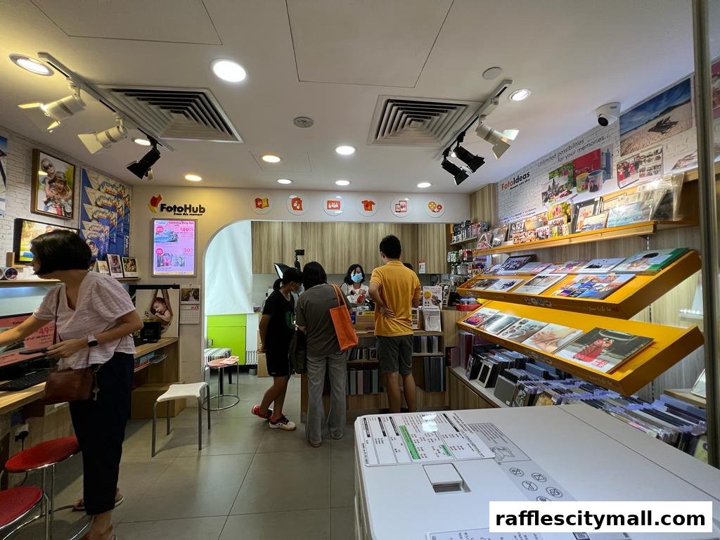 Interior of a FotoHub store with customers and displays of photo albums and printing services.