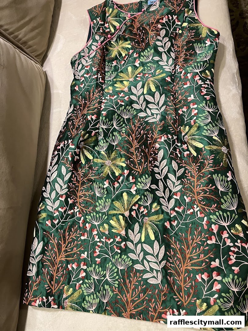 A sleeveless green dress with a vibrant floral and dragonfly print.