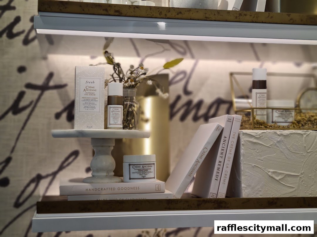 A display of Fresh Crème Ancienne skincare products on shelves with decorative elements.