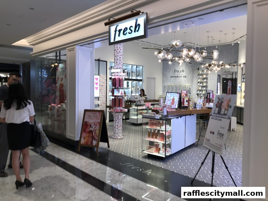 The entrance of a Fresh beauty store with products displayed and customers browsing.