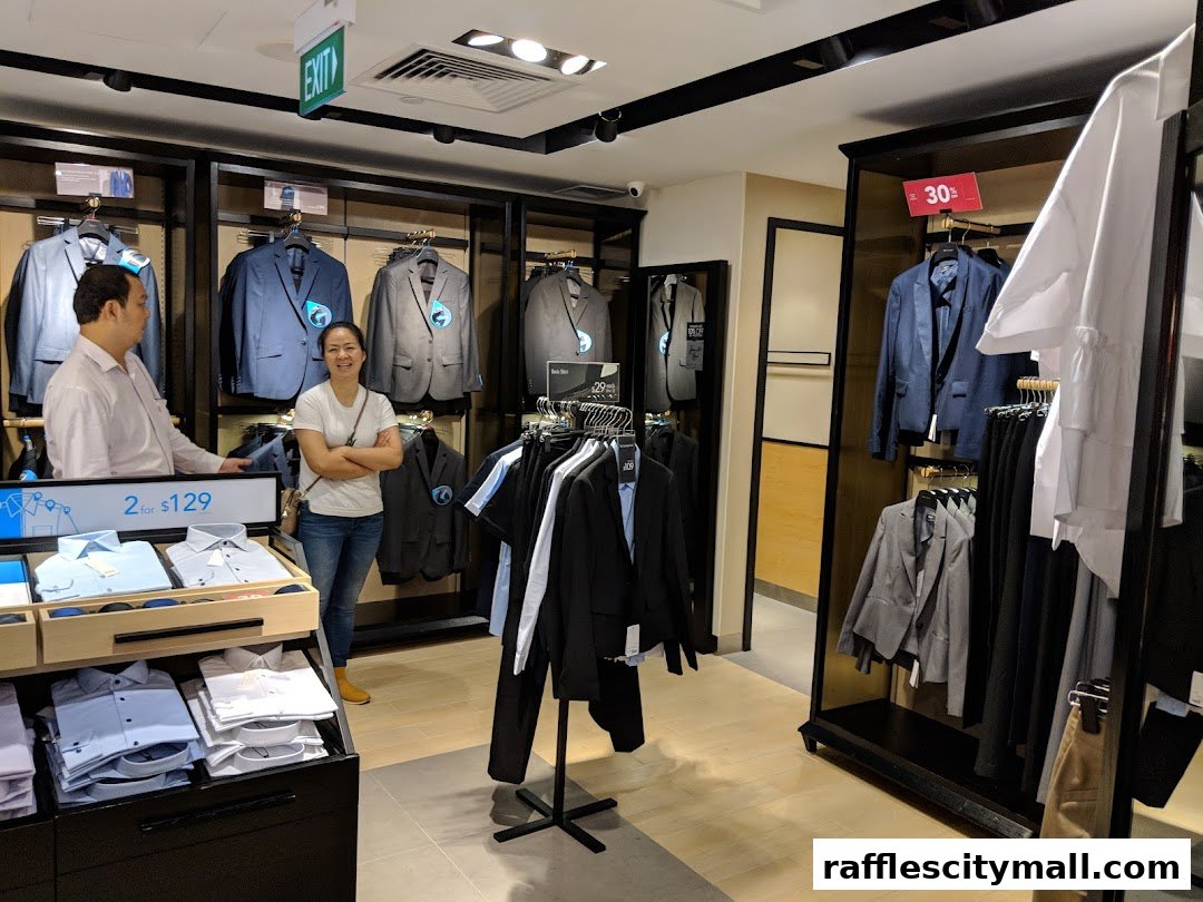 A man and woman stand in a G2000 store displaying suits and shirts.