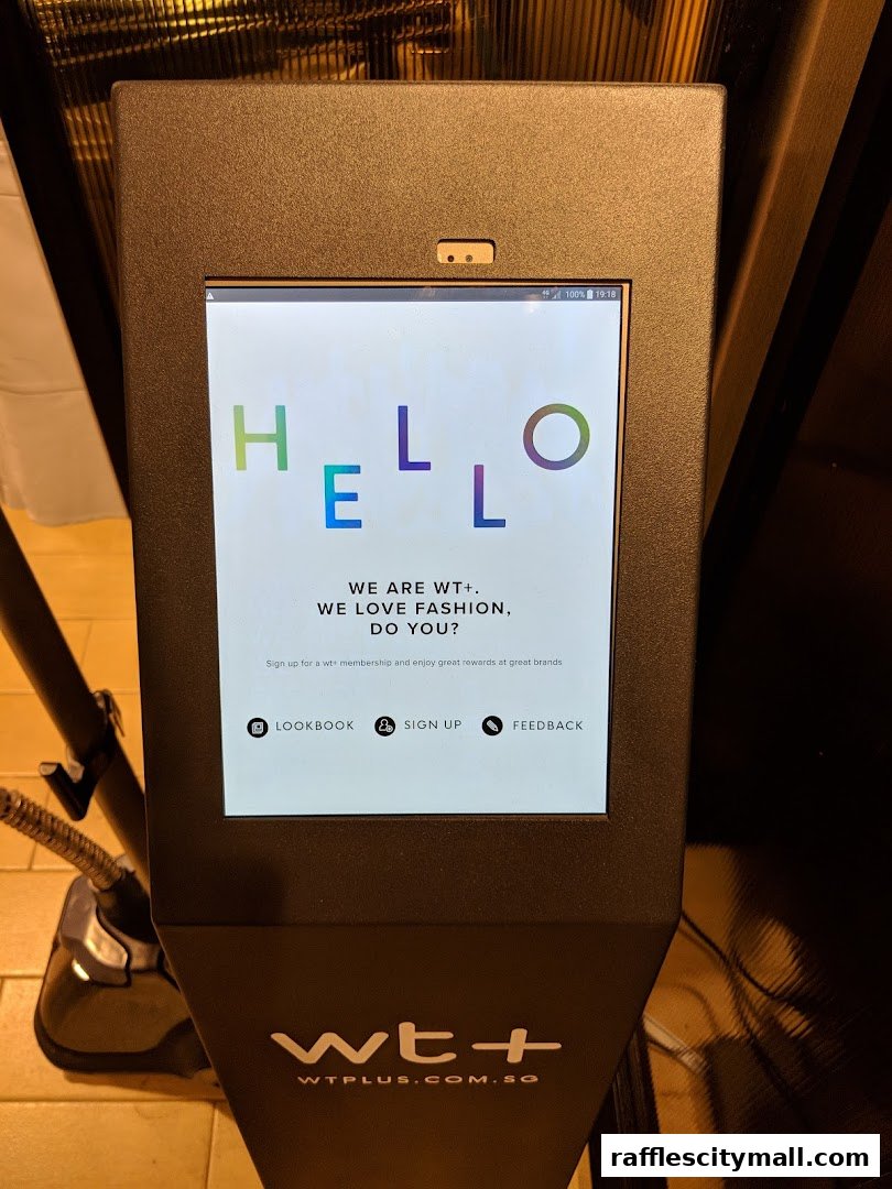 A digital kiosk displays a welcome message and options to sign up for WT+ membership.