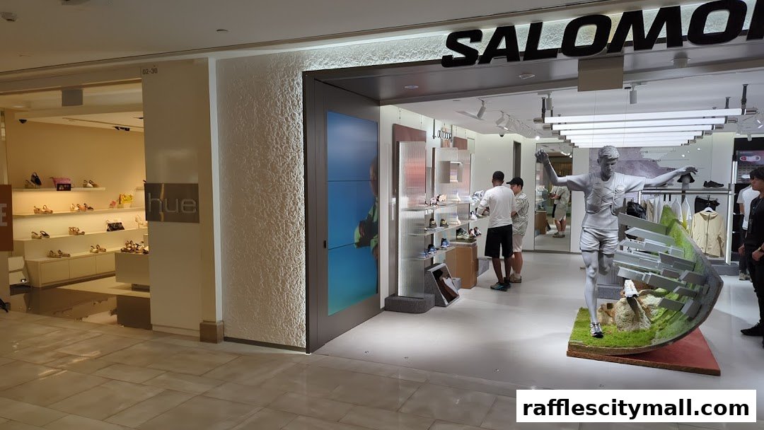 The entrance of a Salomon store with a runner statue and apparel displayed.