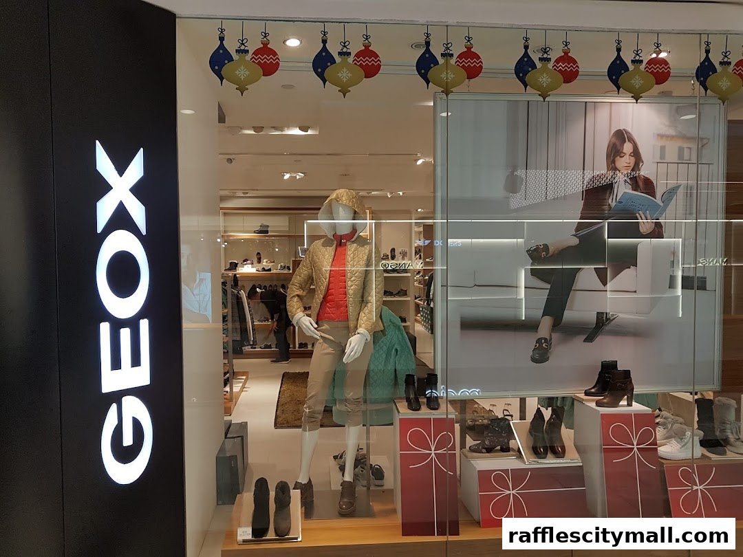 Geox Raffles City shop window display featuring mannequins and shoes, with festive decorations.