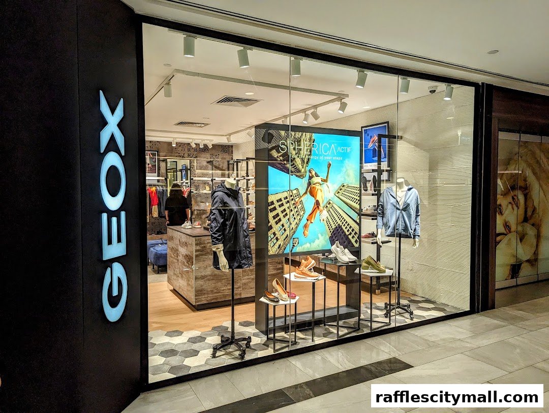 The Geox Raffles City shop front displays shoes and apparel with a large digital screen.