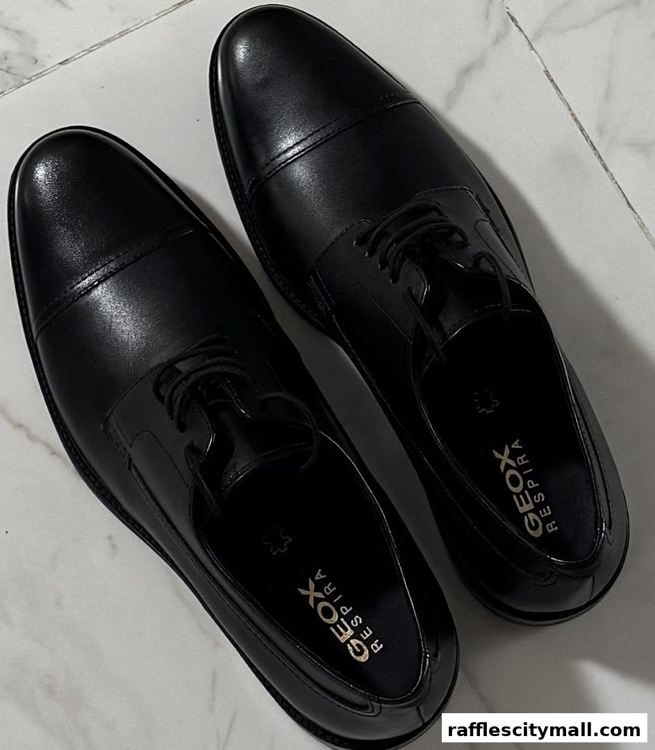 A pair of black leather formal shoes with the Geox Respira logo visible inside.
