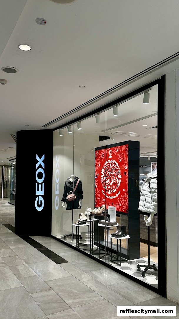 Geox Raffles City shop front with mannequins displaying shoes and jackets, and a festive display.