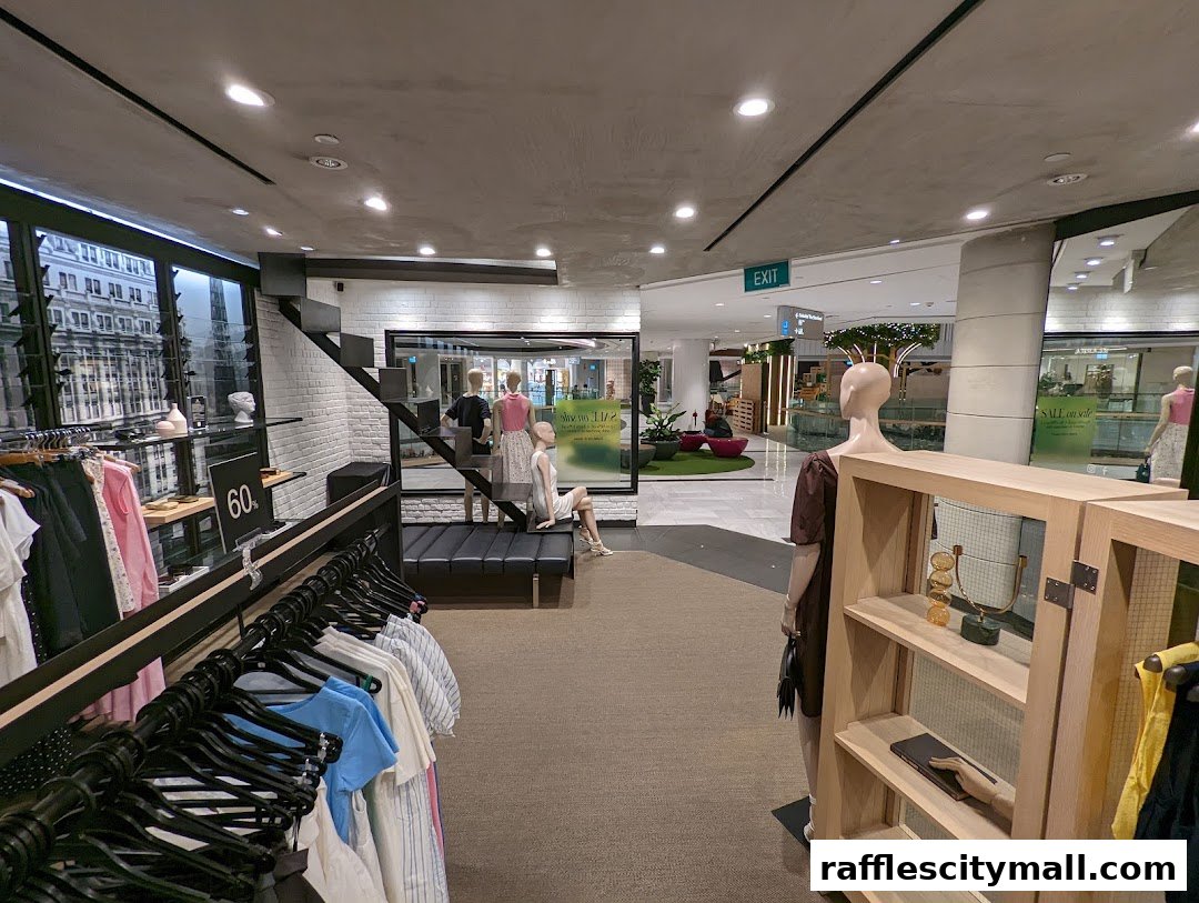 Interior view of a clothing store with mannequins, clothing racks, and a sale sign.