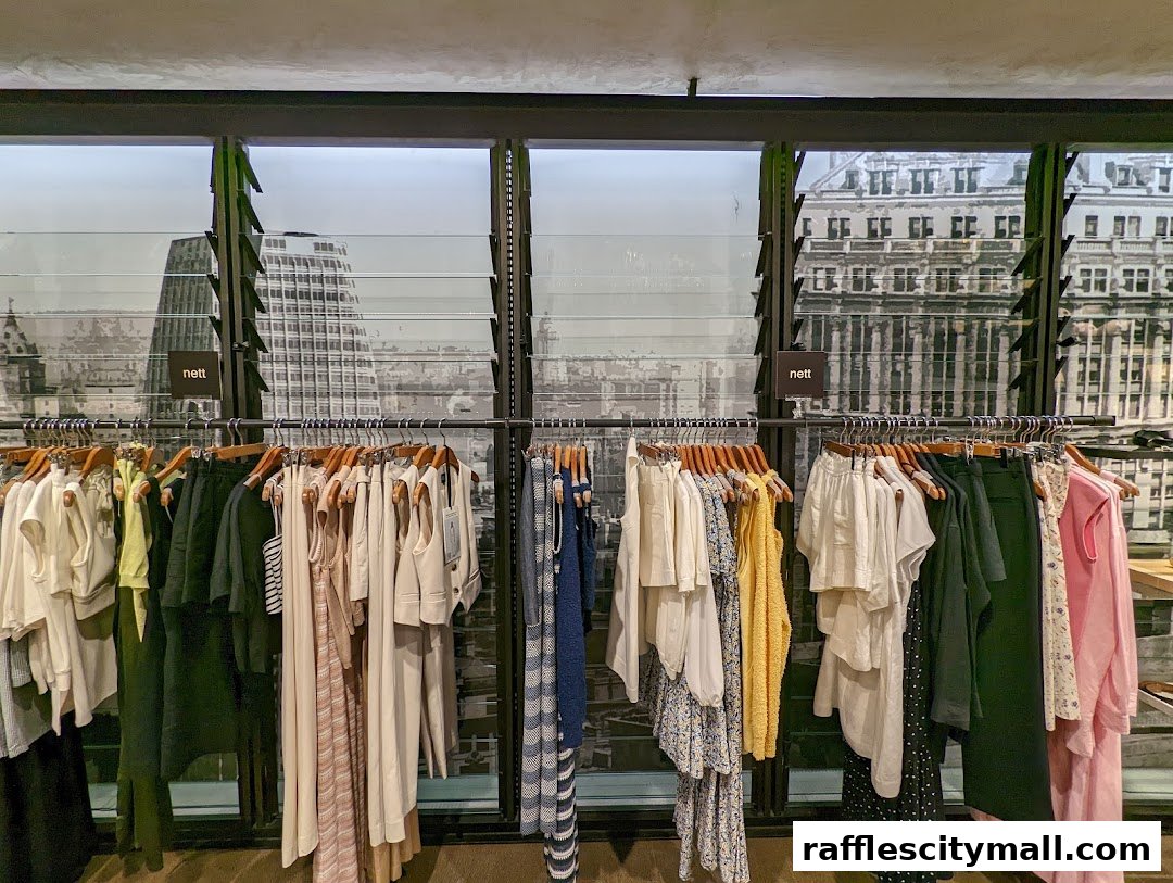 A selection of women's clothing displayed on hangers in a store.