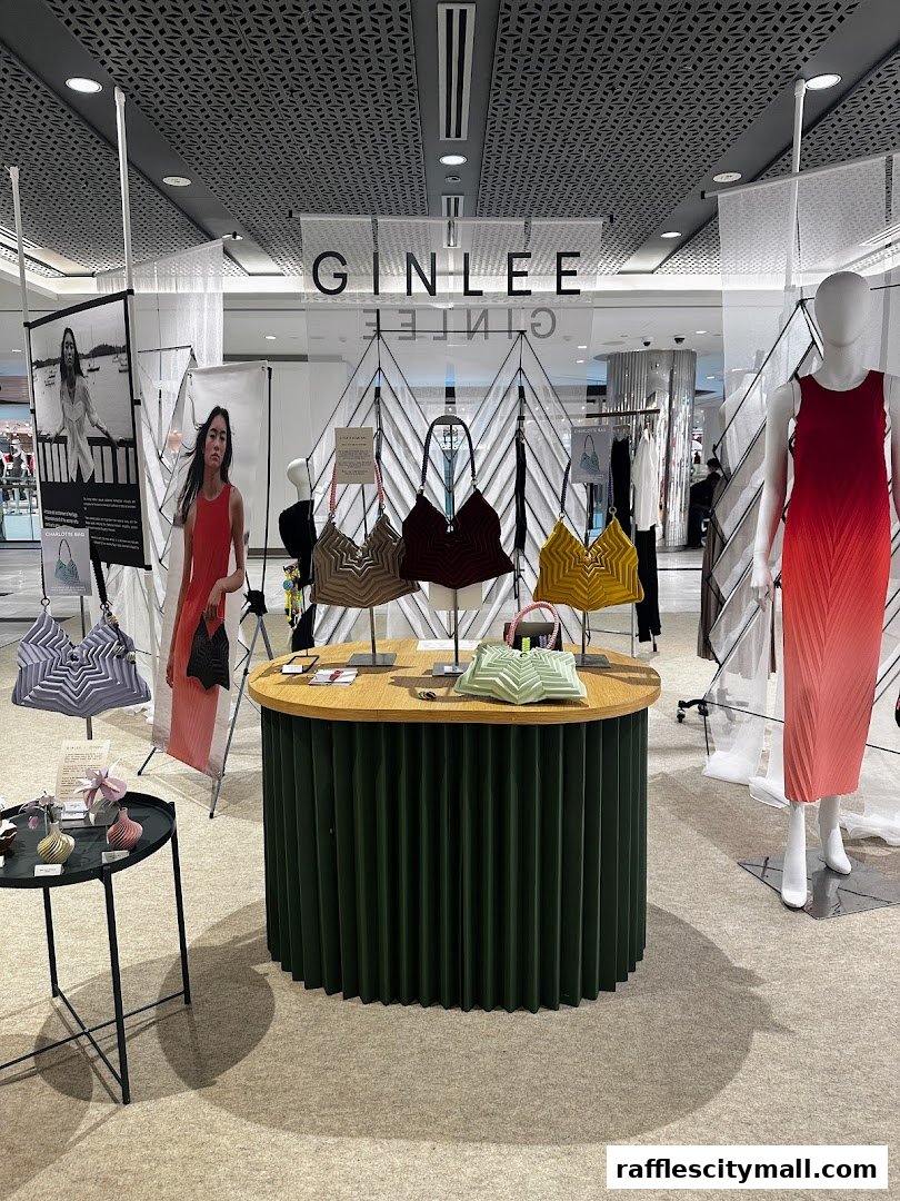 GINLEE Studio display featuring pleated bags and a mannequin in a gradient dress.