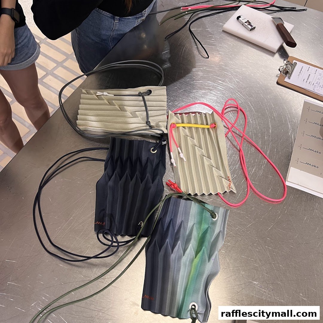 A table displaying several pleated bags in various colors with cords and crafting tools.
