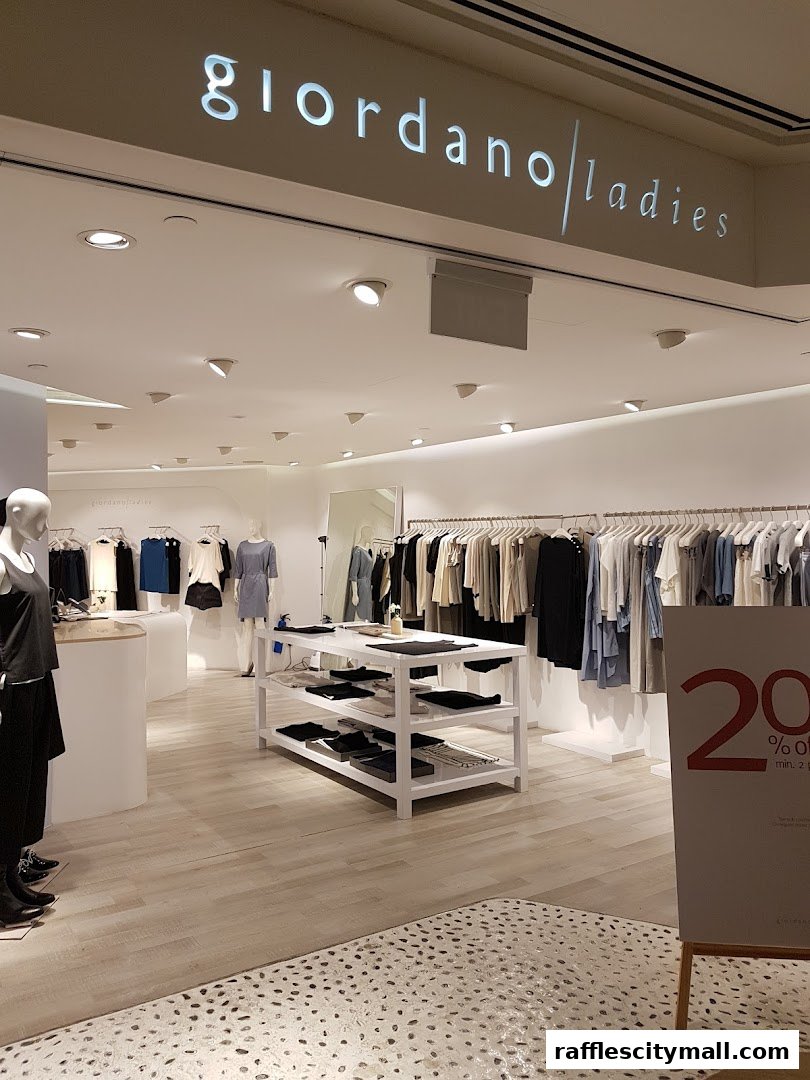 Interior view of Giordano Ladies shop with clothing displays and a promotional sign.